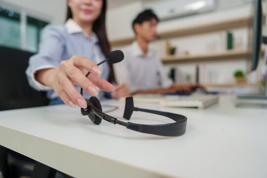 Close up of hand reaching for headset on desk in call center