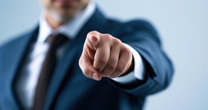 A man in a suit points his finger directly at the viewer