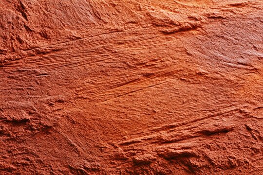 Close-up textured view of rough, layered reddish-orange rock surface