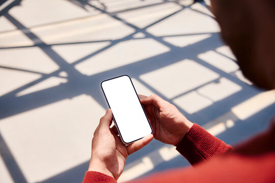 Hand holding smartphone with blank screen mockup outdoors
