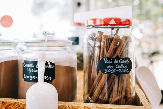 Glass jars of cinnamon and scoops in a zero waste bulk store