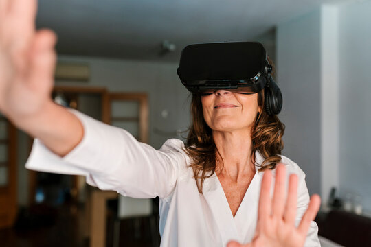 Woman smiling while using virtual reality headset at home