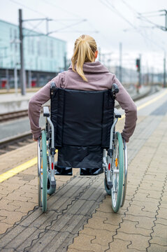Woman in wheelchair waiting at station platform