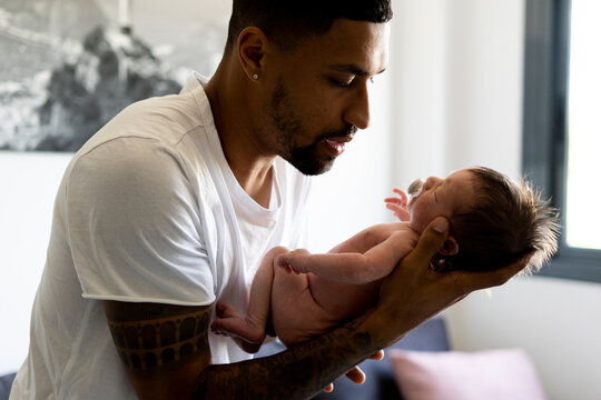Affectionate father holding his nude newborn baby
