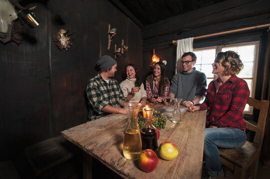 Group of young people drinking in mountain hut