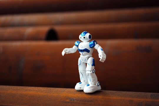 Robot toy on rusted pipe in warehouse