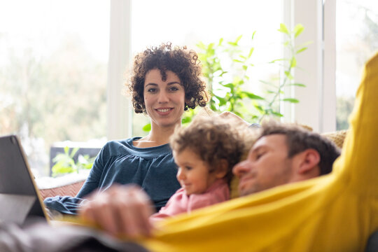 Family lying on couch watching movie on theit tablet