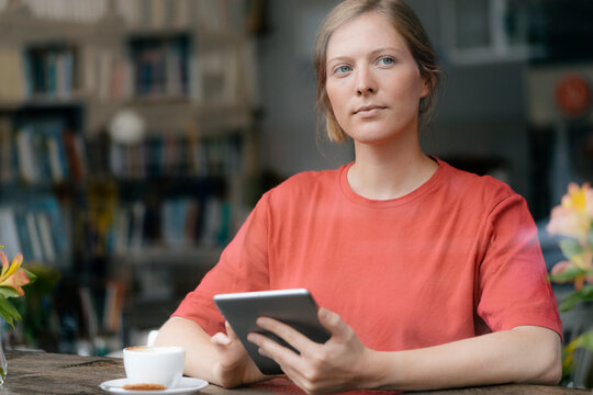 Young woman using tablet at the window in a cafe