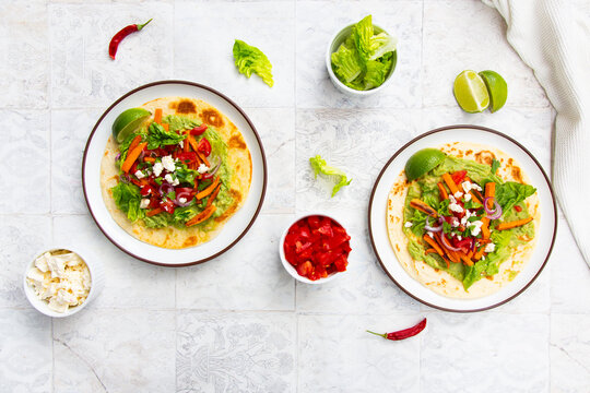 Vegetarian wrap with sweet potato avocado and feta on tiled table
