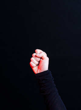 Raised fist on black background symbolizing power and protest