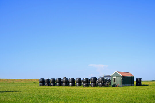 Black bales sit near an improvised theatre in a Terschelling polder
