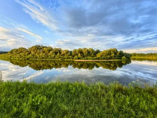 A summer river landscape: sunset, wildflowers, and the sky. © Nadzeya Pakhomava
