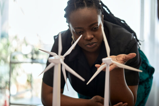Woman examining wind turbine models at coworking office