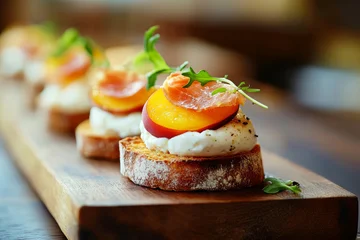 Cheesy burrata crostini with prosciutto on a wooden board at a restaurant in the afternoon © Boyan Dimitrov