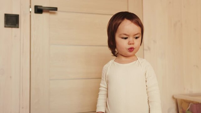Three-year-old girl smiling and talking with expressive emotions in a cozy home interior