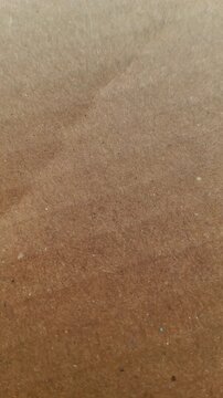 Cardboard sheet or cardbox paper light brown colour blank surface minimal abstract texture background for graphic design with spinning and rotating motion.