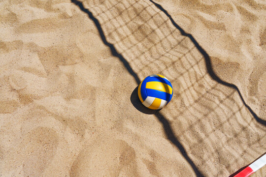 Beach volleyball court with a volleyball ball placed in the sand.