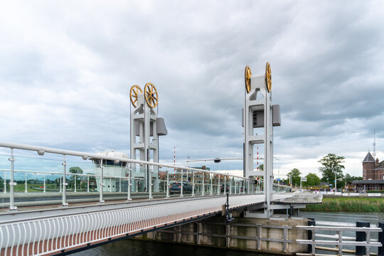Kampen, Netherlands &ndash; June 6, 2026: The modern Stadsbrug crossing the IJssel River features twin lifting towers, glass railings and contemporary engineering beneath dramatic storm clouds.