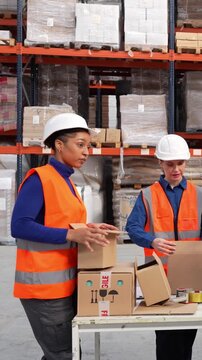 Diverse team of women packing products for shipment in a warehouse. Female employees preparing merchandise and sealing cardboard boxes with tape