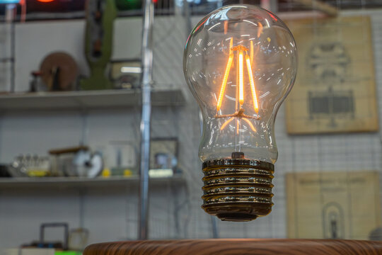 Wireless energy transfer and innovative power generation technology represented by levitating retro edison glass lamp with glowing orange filament loop