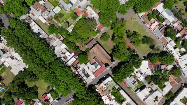 Top down aerial orbit descends on Colonia del Sacramento streets and buildings Uruguay, drone backdrop