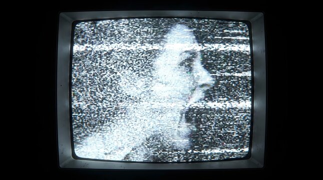 Vintage retro television with white noise and static interference showing a spooky screaming silhouette woman profile for halloween concept