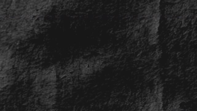 4K animation of seamless looping dark charcoal paper texture with subtle organic surface movement and grainy cinematic abstract background motion
