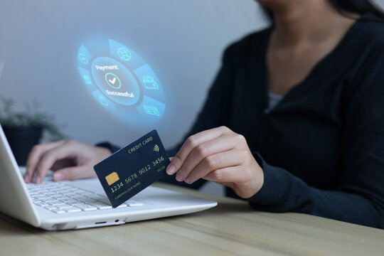 Woman Holding Credit Card And Typing On Laptop Keyboard While Hologram Displays Successful Payment Message