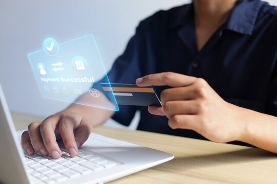 Person Typing On Laptop While Holding Credit Card With Display Showing Payment Successful Message