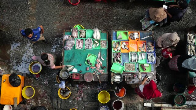 A bustling fish market comes alive during the early morning hours, where vendors and buyers engage in the daily trade of fresh seafood and fish. Operating from around midnight until 7am