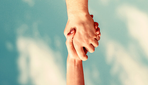 Helping hand concept, support. Hands of on blue sky background. Helping hands concept, support. Closeup help arm. Vertical
