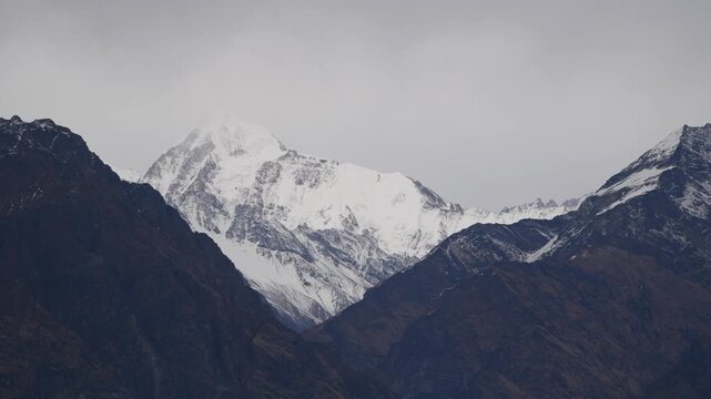 Cinematic Zoom Out Of Snow Capped Himalayan Peak Framed By Dark Mountains
