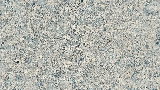 Close-up view of a rough, granular grey surface with scattered dark and light specks, resembling concrete or stone texture.