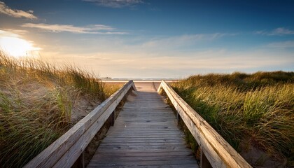 Obraz premium The End Of A Boardwalk Through Grass Covered Dunes Onto A Maine Beach Early Morning