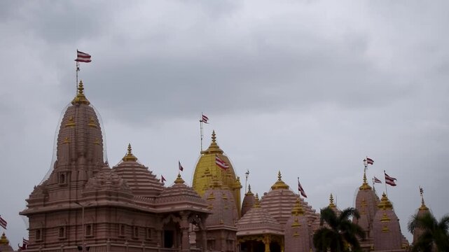 Spiritual view of sacred Swaminarayan Temple at Poicha, Nilkanth Dham, featuring ornate temple spires and divine architecture under a cloudy sky, reflecting Hindu faith, devotion and peace in Gujarat.