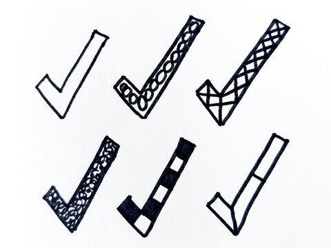 Six hand-drawn black ink check marks and tick doodles arranged on white paper, ideal for approval, verification, icon design, notes, sketches, and creative projects conveying confirmation and success.