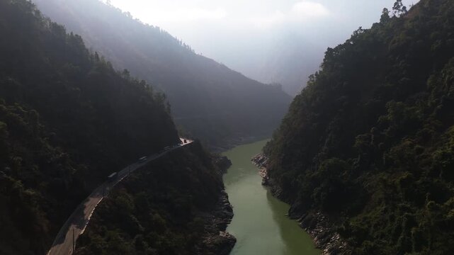 Aerial tilt shot of the curvy Prithvi highway through a mountain valley in Nepal