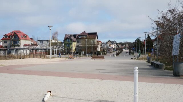A peaceful static ground-level shot of traditional coastal houses lining the scenic seafront in Jastarnia on the Hel Peninsula, Poland, capturing the quiet charm of the Baltic coast.