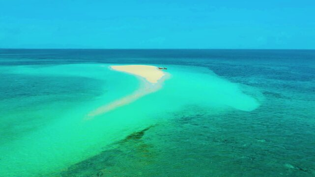 An expansive aerial perspective of the iconic, crescent-shaped white sandbar surrounded by turquoise waters in Camiguin, Philippines.