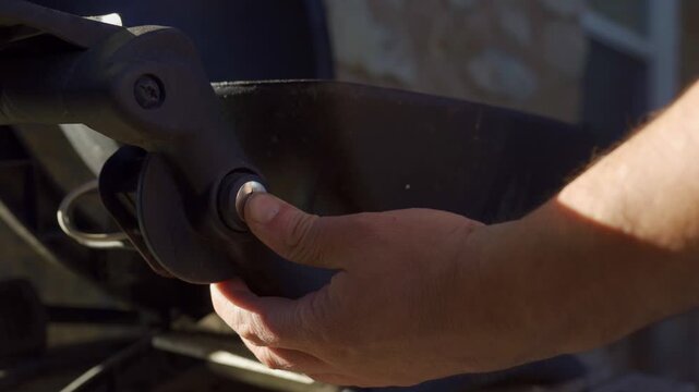 Close-up shot of a person starting a Weber barbecue grill outdoors in bright natural sunlight, highlighting hands, grill details, ignition process, and inviting summertime backyard mood.