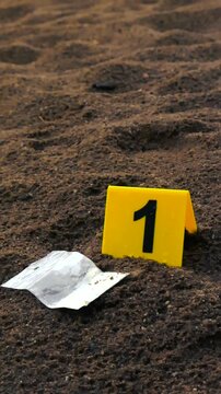 Raindrops falling in slow motion on a yellow evidence marker and a plastic bag of white powder, symbolizing found illicit drugs or narcotics at an outdoor crime scene investigation