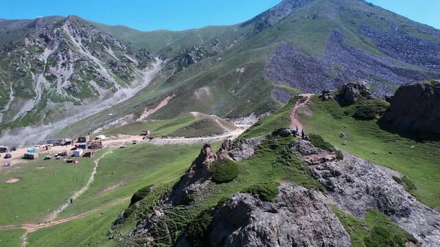 Rocky outcrops rise above green slopes at Badgoi Pass in the Hindu Kush, Kalam, Pakistan