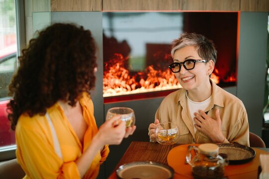 Women drinking tea having generational friendship conversation