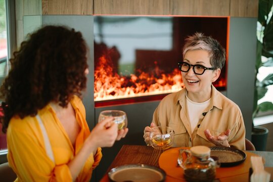 Mature woman and young woman enjoying conversation over tea