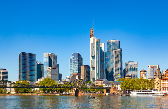 Frankfurt, Germany - May 15, 2026: Scenic view of financial district corporate skyscrapers and Eiserner Steg iron bridge across the Main river