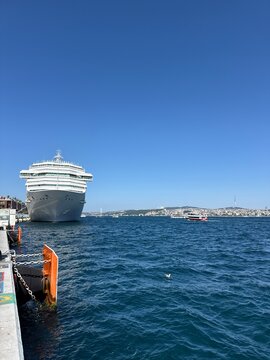 Luxury cruise ship sailing across the deep blue Mediterranean Sea, stunning coastline views, bright sunlight, elegant and cinematic