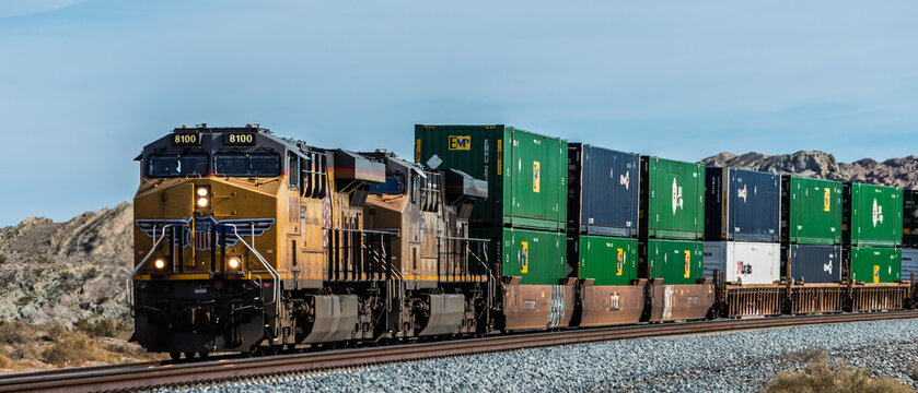 Palm Springs, USA - January 22 2018: A powerful Union Pacific Railroad freight train transporting double-stacked containers through the American landscape.