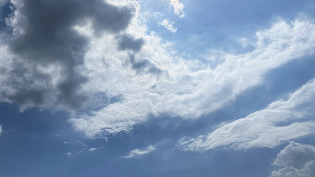 Layered wispy white clouds against hazy blue sky