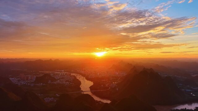 Golden City Lights and Fire Clouds Over Karst Mountain River Valley at Sunset