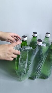 Pack of bottled drinking water on floor, woman taking water bottle, emergency water supply, household water reserve and preparedness concept.